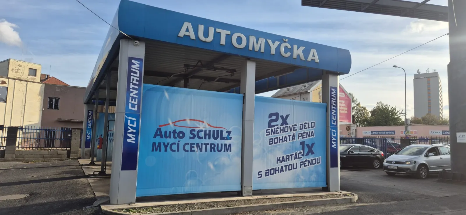 Boční pohled na mycí boxy s bannerem Auto Schulz Mycí centrum